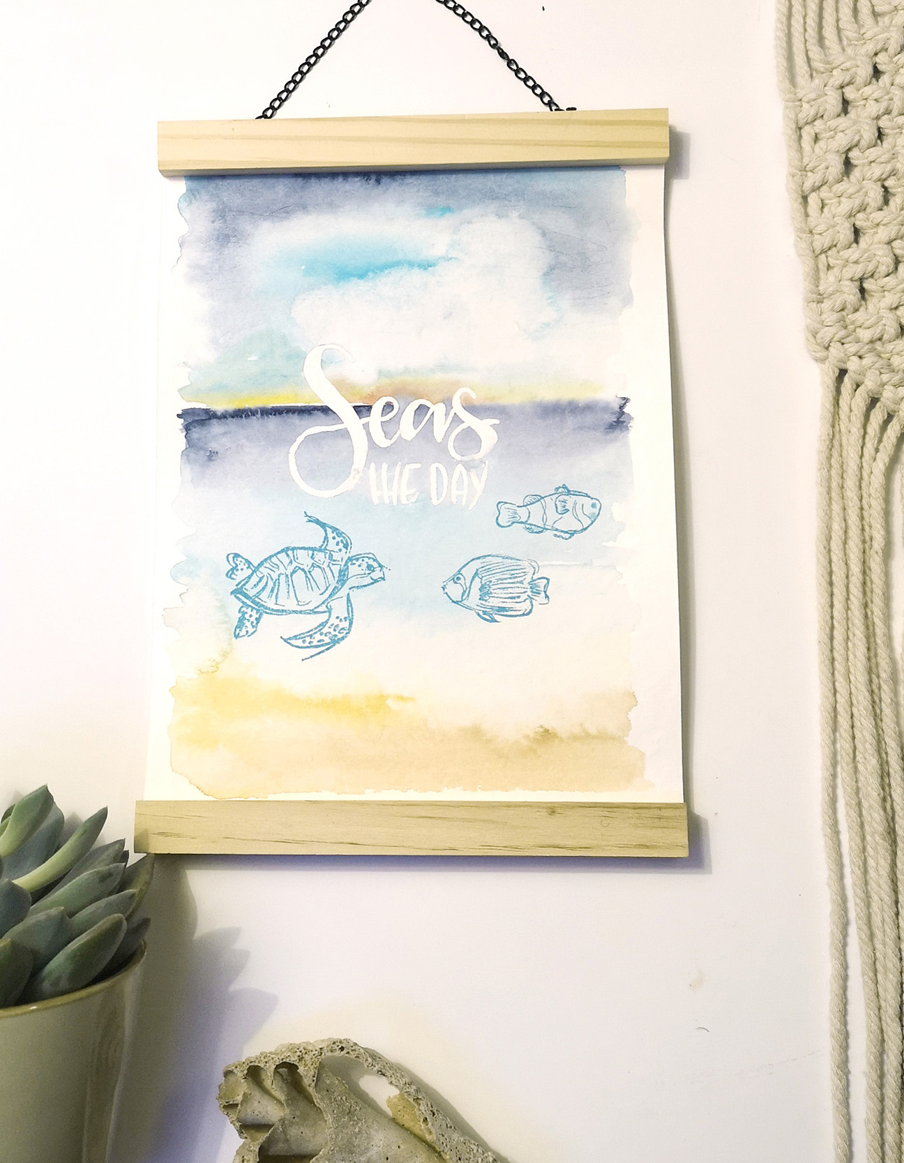 Affiche aquarelle finale avec lettrage à la main, citation « Seas the day », couleurs vives et baguettes en bois magnétiques pour accrocher