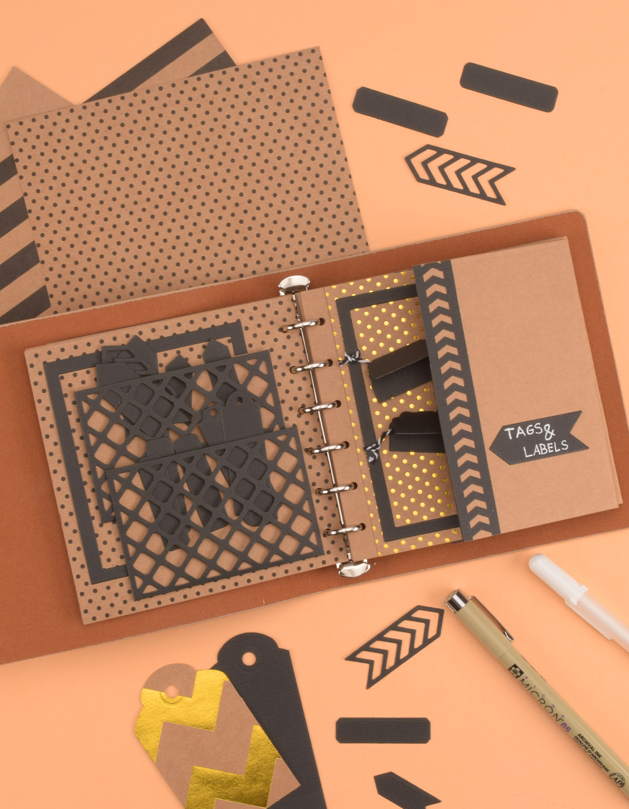 Fertiges DIY-Projekt zeigt ein Bullet Journal mit Kraftpapier, Taschen und Etiketten, dekoriert mit geometrischen Mustern und Schnur.