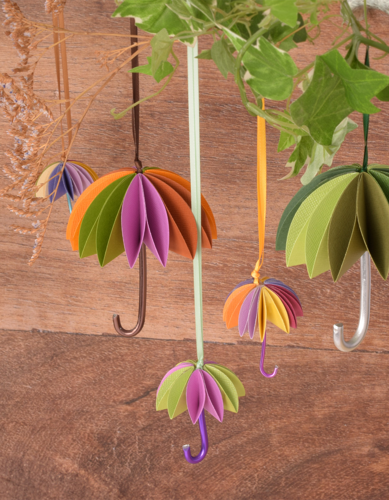 Hängende 3D-Papierregenschirme in Herbstfarben als dekorative, handgefertigte Anhänger.