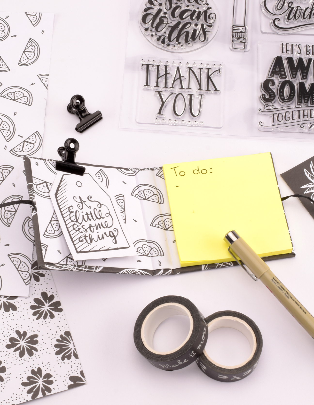 Geöffnetes DIY-Post-It-Büchlein mit Paperfuel-Stempeln, Washi-Tape und Designpapier zur persönlichen Gestaltung.