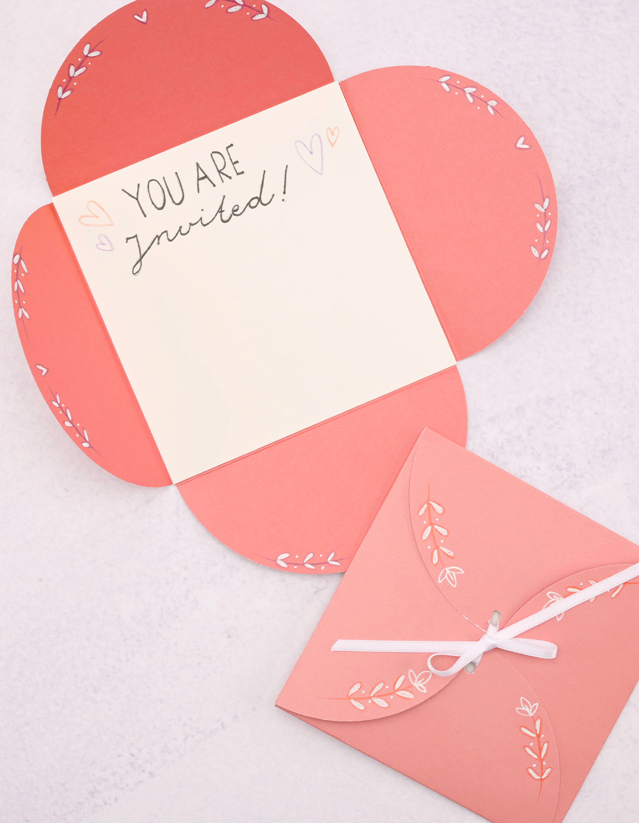 Finished handmade invitation card with floral design and ribbon closure DIY