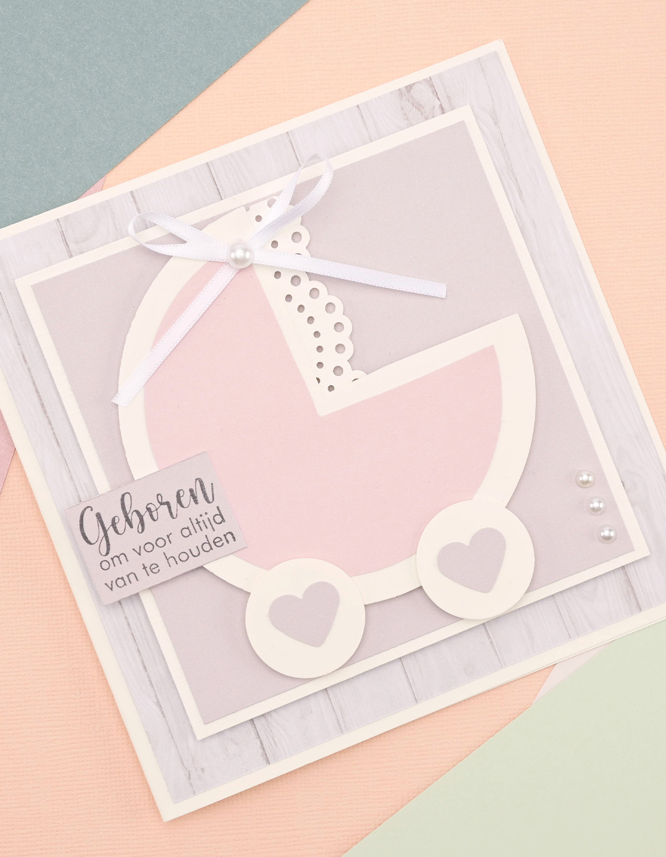 Fertige handgemachte Babykarte mit Kinderwagenmotiv in Pastellfarben und Kartonlagen