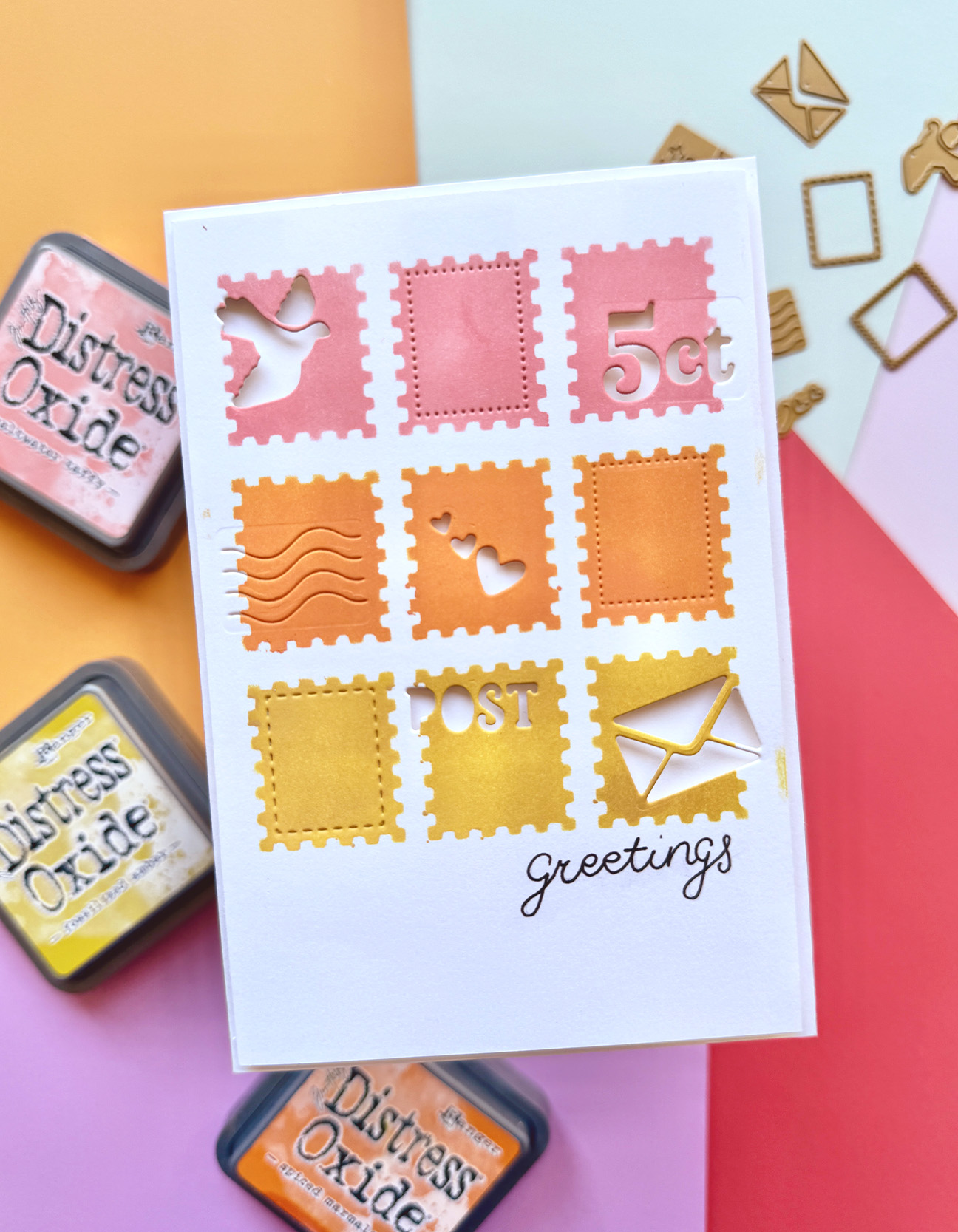 Finished handmade postage stamp card with pink orange and yellow stamps and postal die-cut details