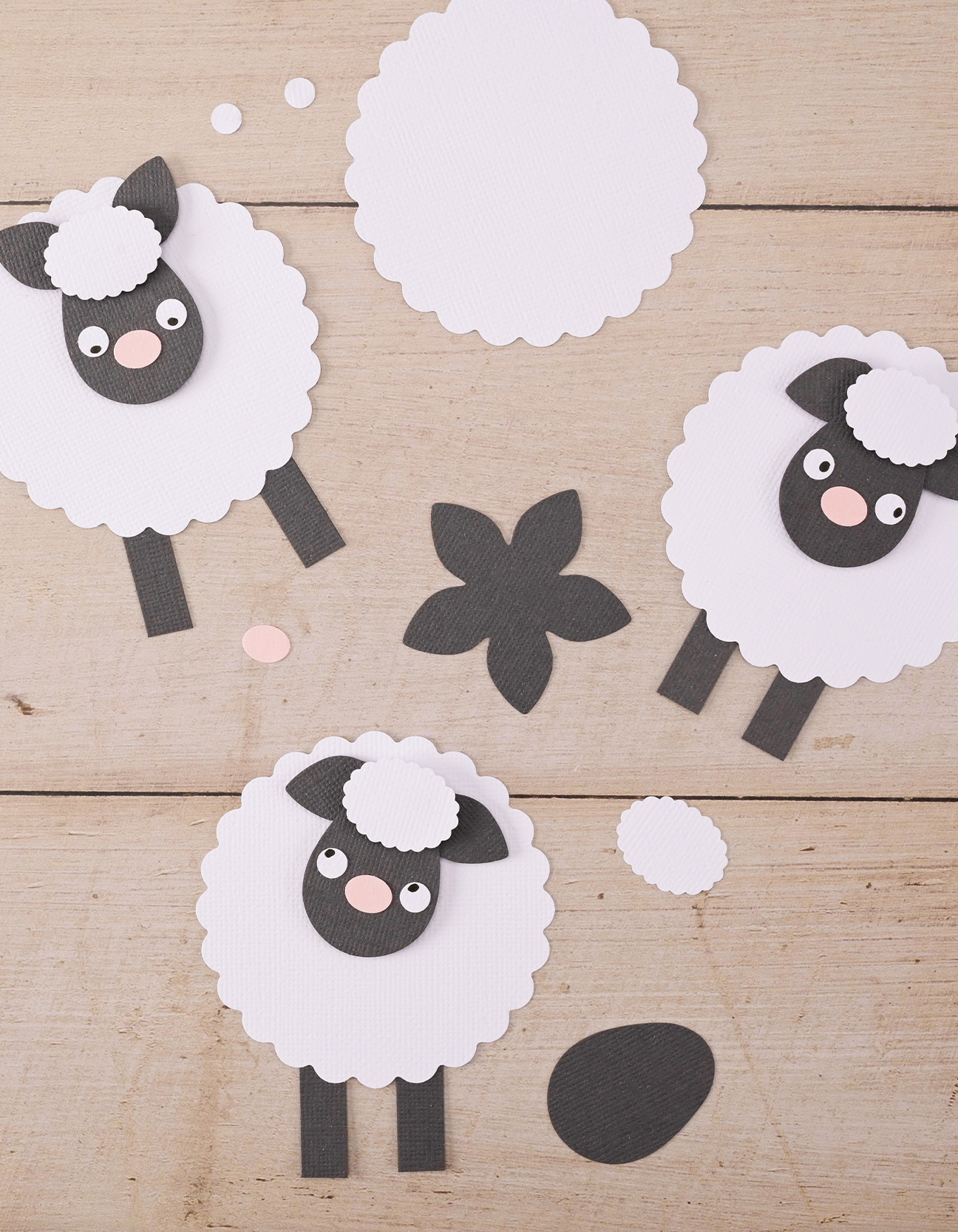 Finished paper lamb craft made from cardstock with scalloped body, black head and cute pink nose