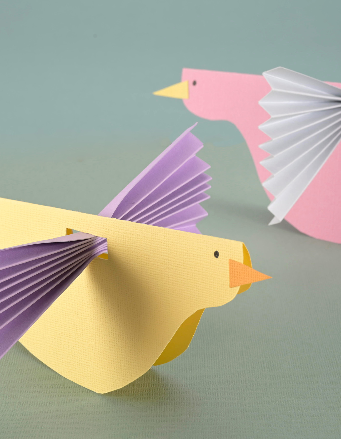 Finished colorful paper birds made from cardstock with folded wings for spring crafts