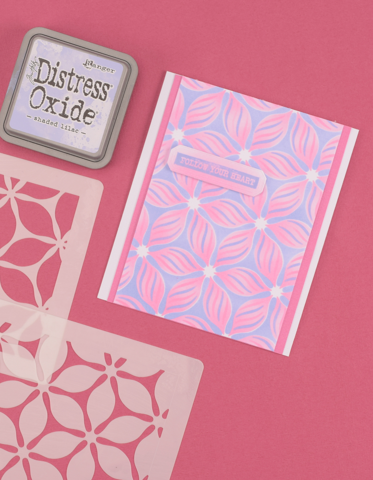 Afgewerkte kaart met layered stencils, roze en blauwe Distress Oxide inkt en een verhoogde tekst.