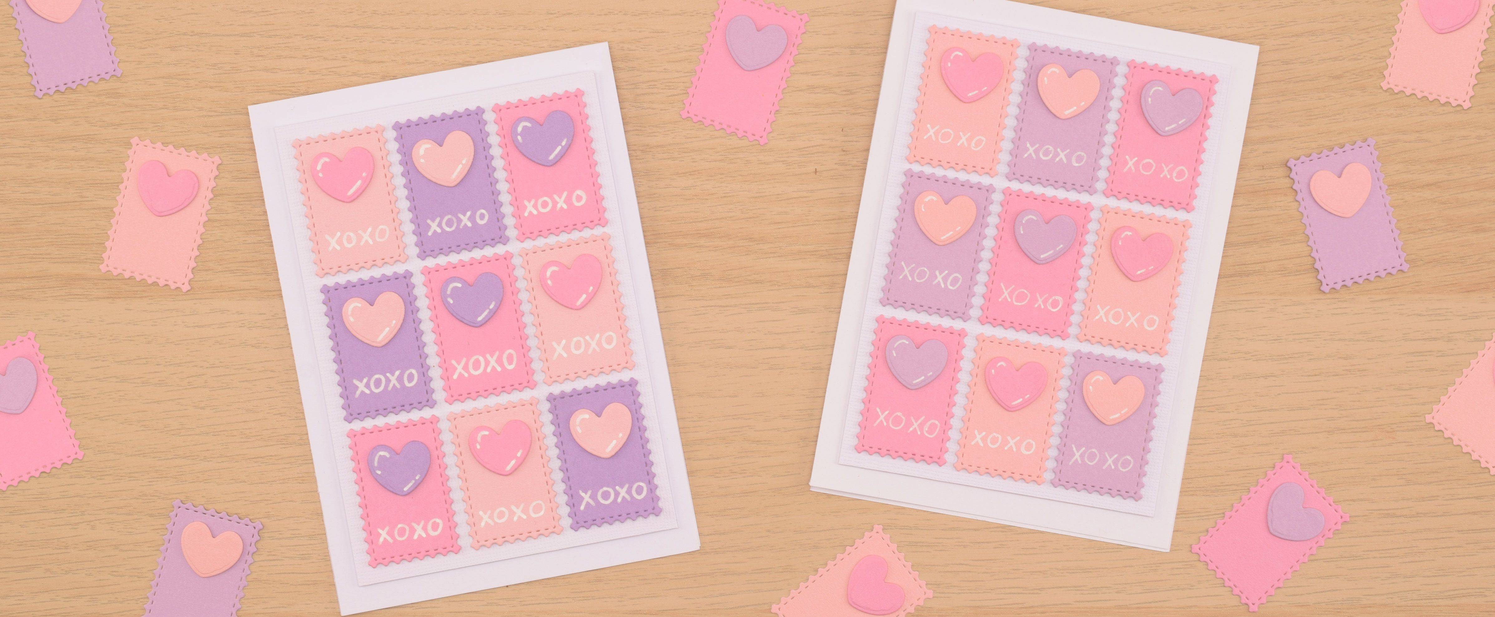 Tarjetas de San Valentín con corazones rosas y morados y diseño XOXO, sobre una superficie de madera con piezas decorativas dispersas.
