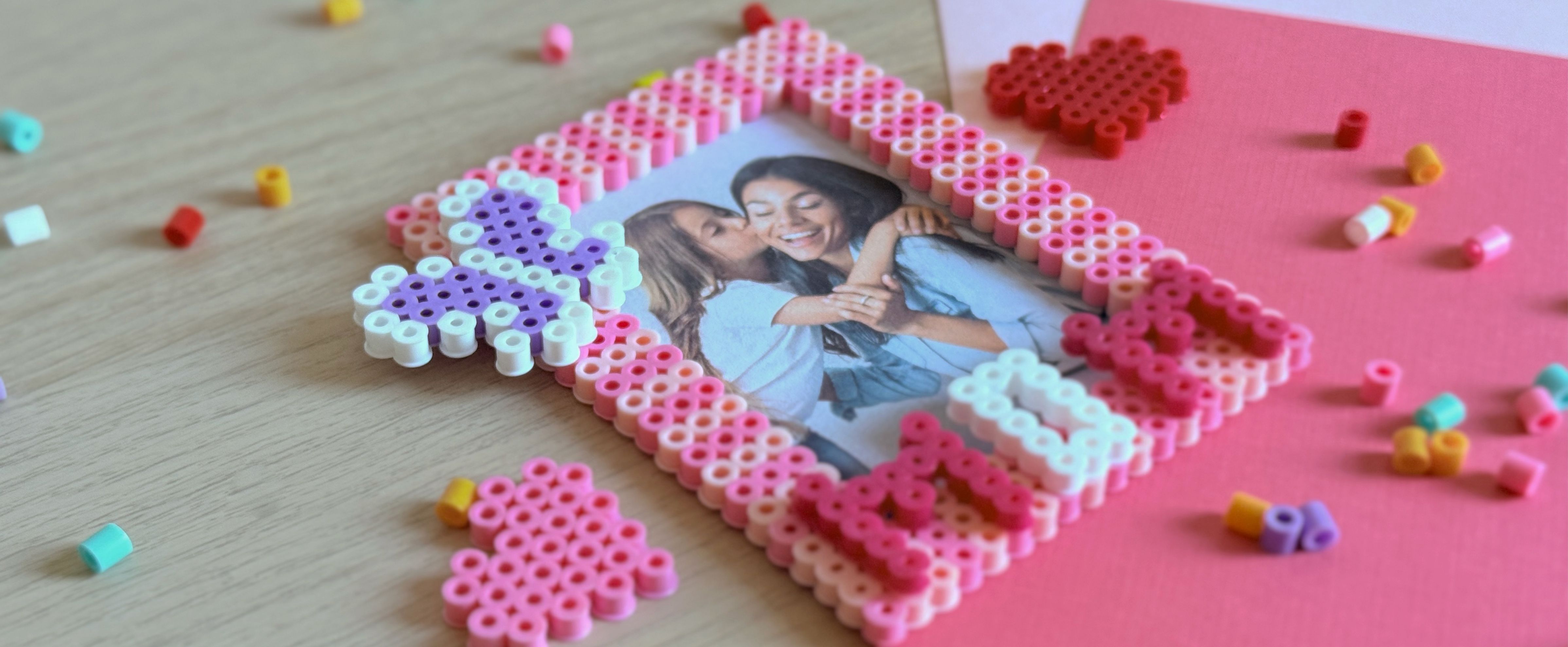 Cadre photo en perles à repasser décoré de motifs de cœurs.