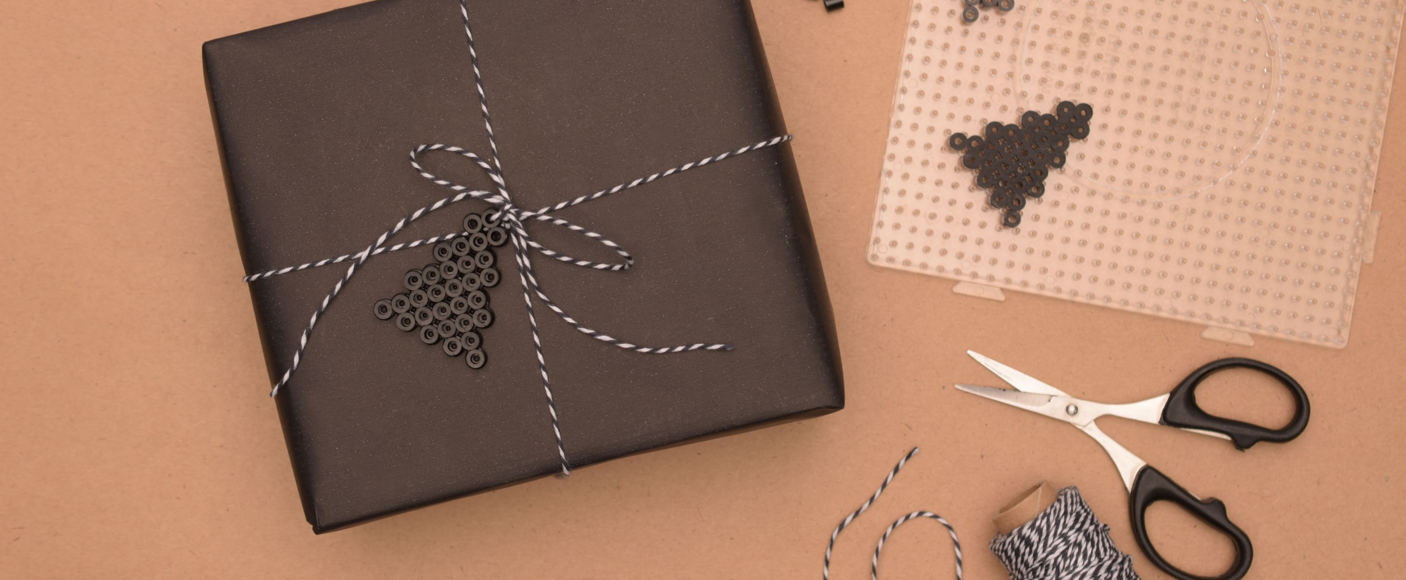 Kerstboom versiering gemaakt van strijkkralen in donkere kleuren, een nostalgisch project voor kerstdecoratie.