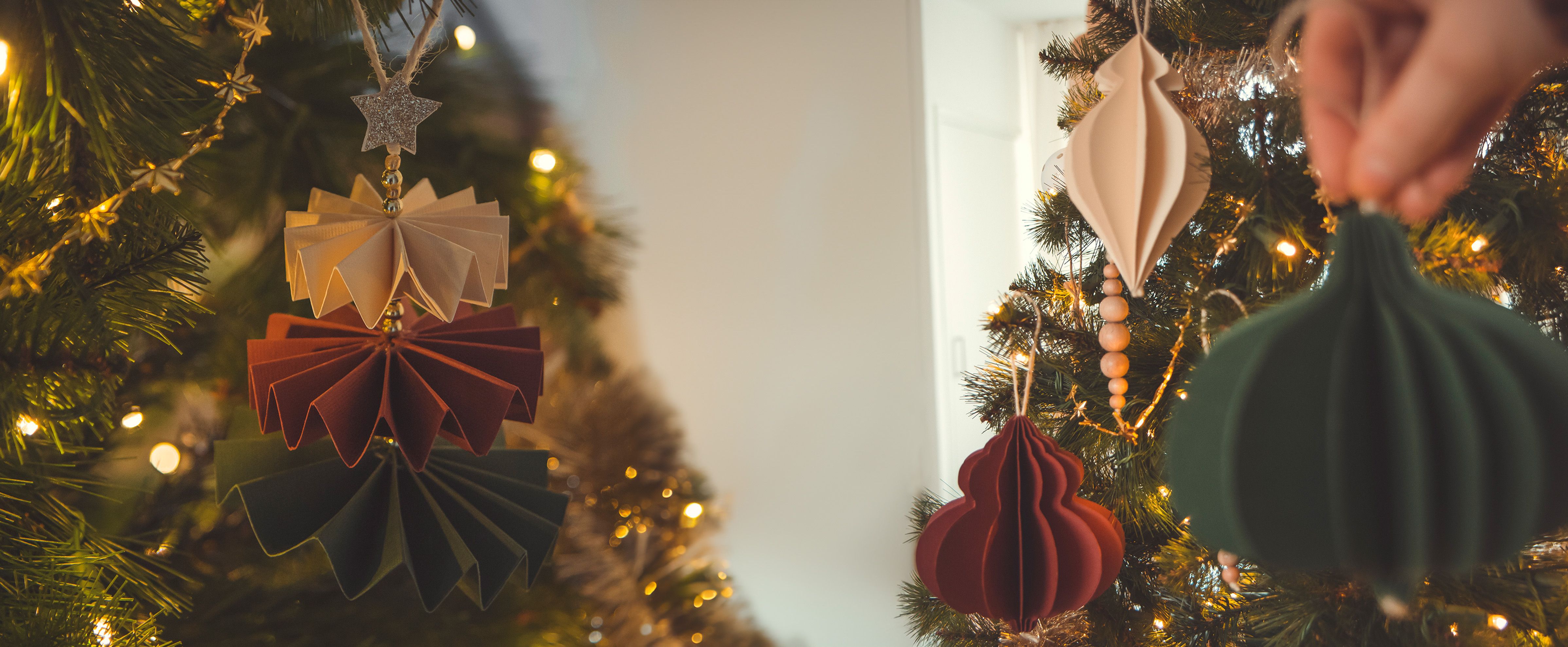Bolas de Navidad de papel en diferentes formas – adornos creativos en 3D con tonos cálidos.