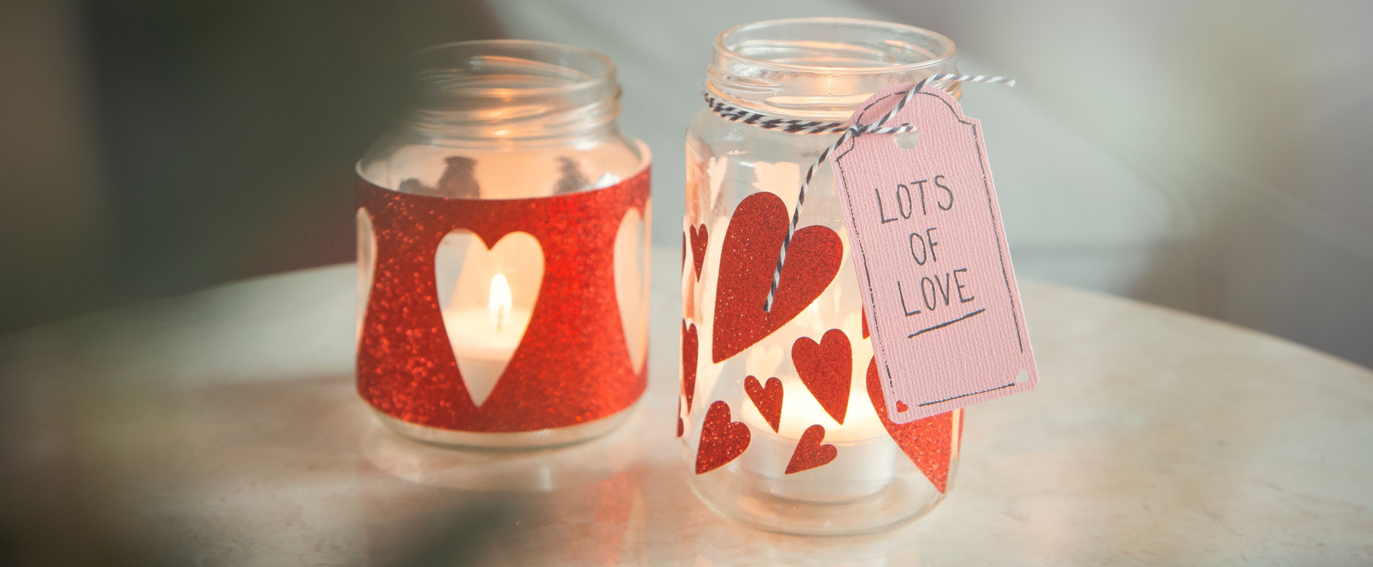 Photophore en verre décoré de cœurs pour une lumière douce et chaleureuse.