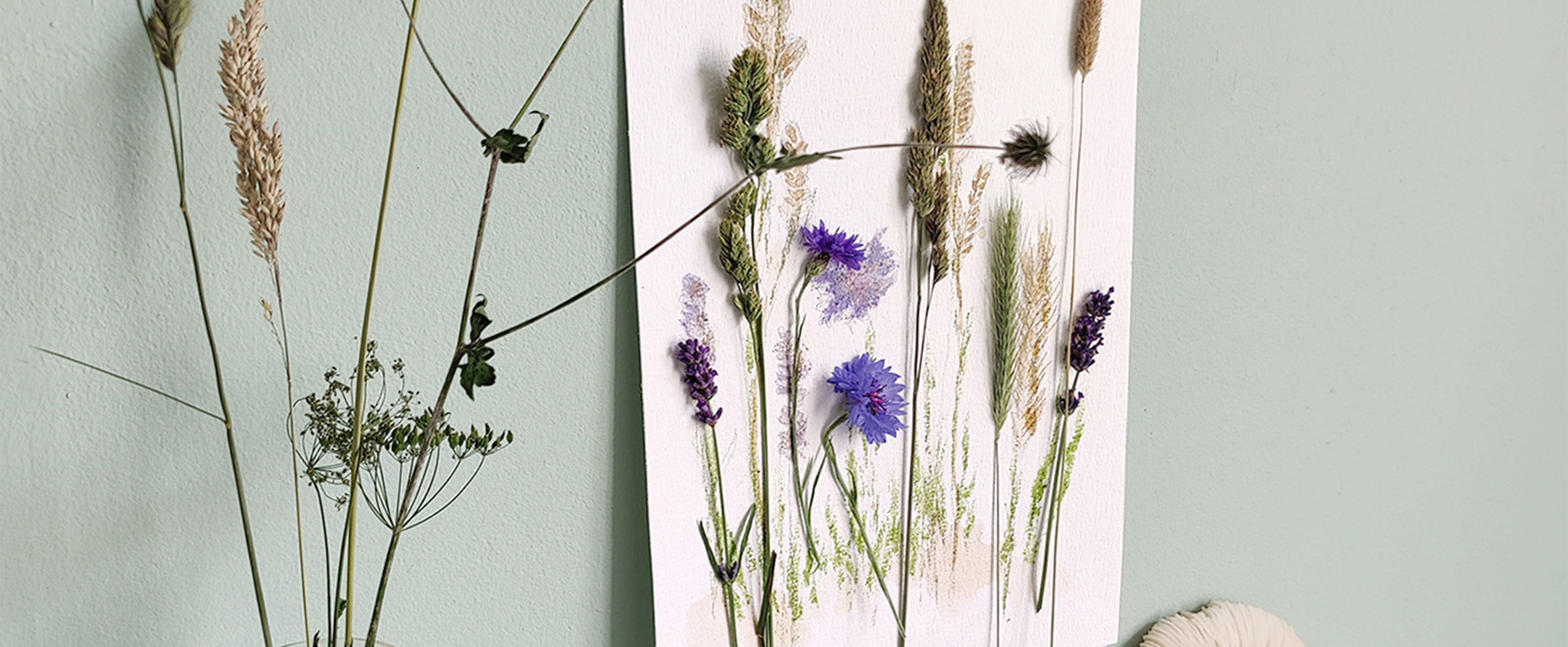 Decorazione da parete con fiori secchi su pannello chiaro, perfetta per home decor naturale per adulti.