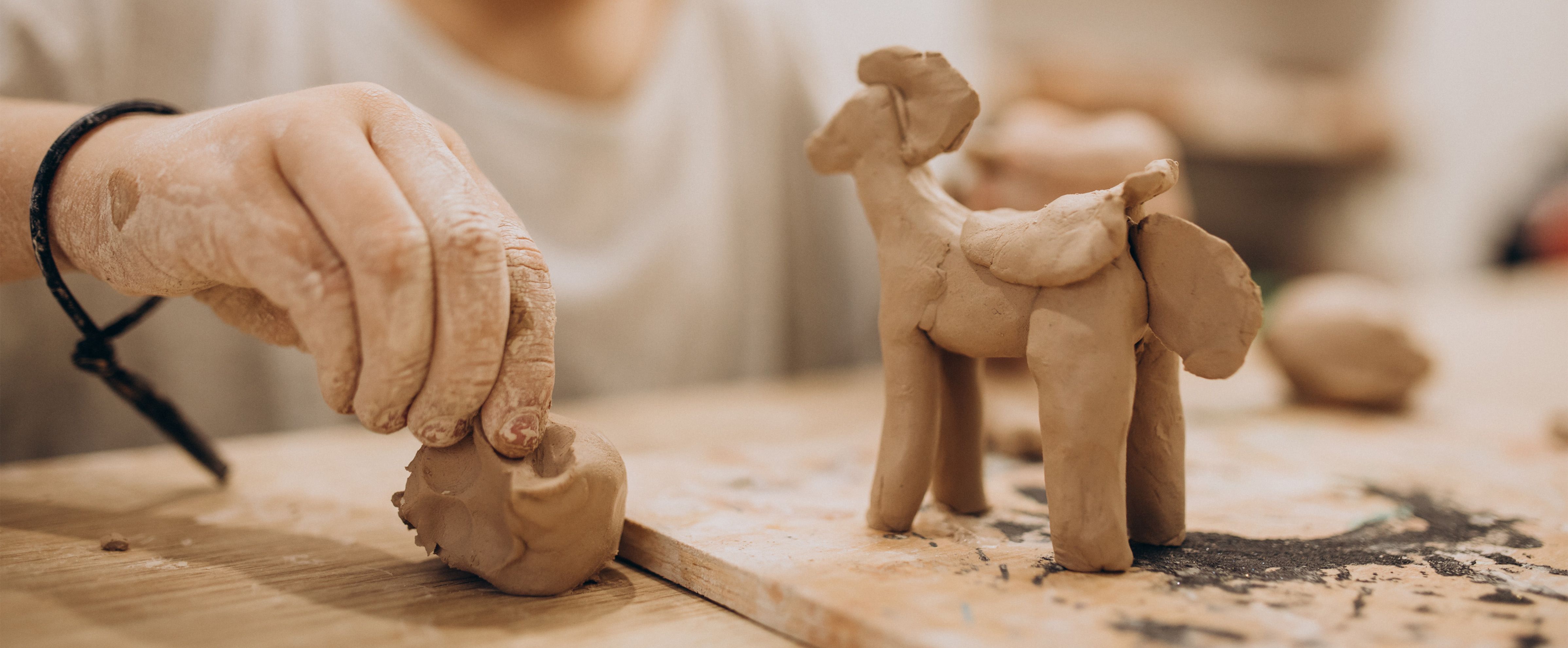 Niño modelando animales de arcilla con las manos, una idea creativa para chicos que disfrutan construir