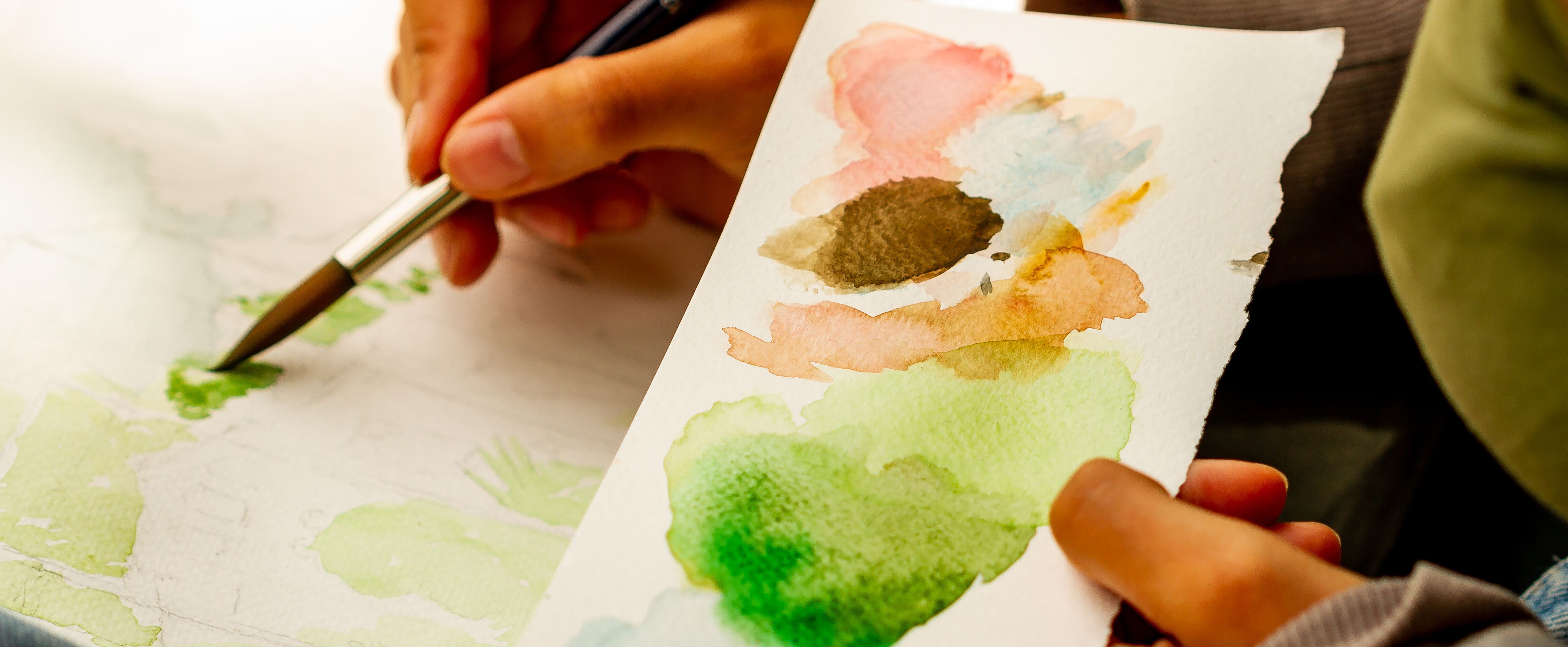 Painting with watercolour on paper and blending soft colours with a brush