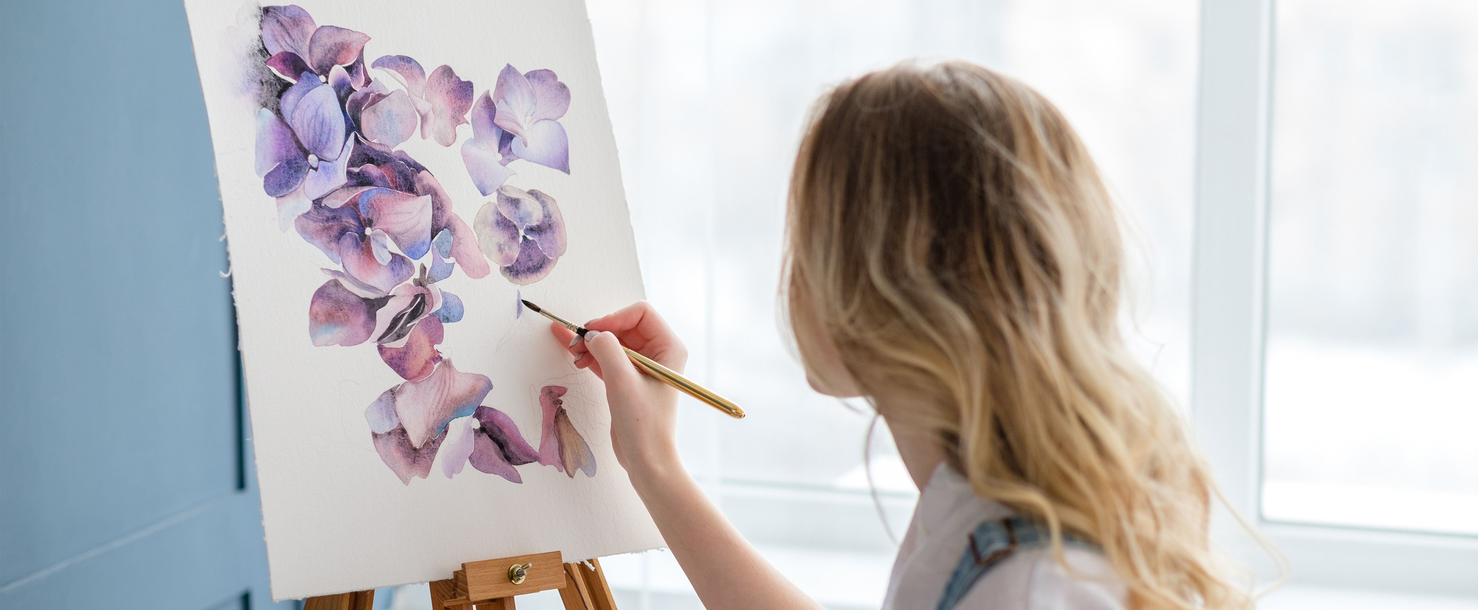 Painting purple flowers on canvas as a creative painting hobby