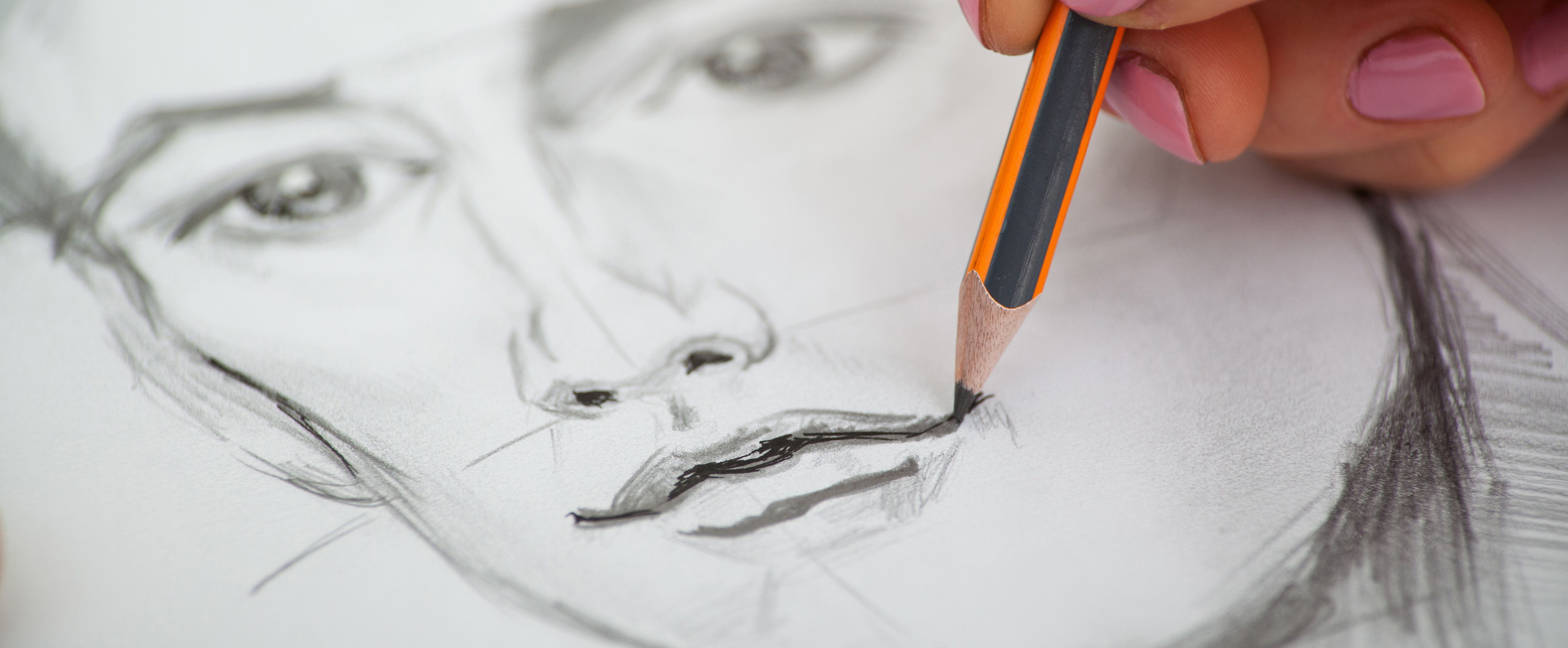 Close-up of drawing a portrait with graphite pencil and shading details