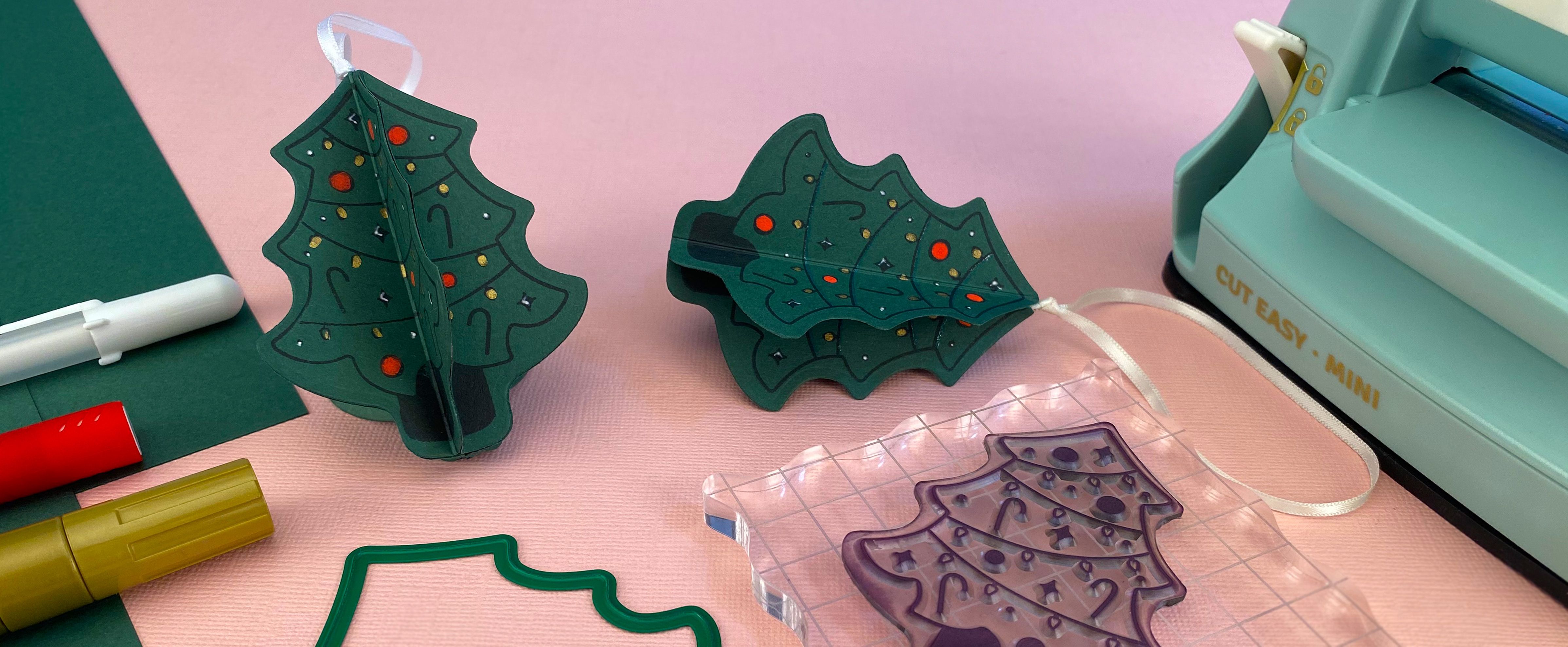 Zelfgemaakte kerstboom van papier als ornament, gemaakt met groene cardstock en een kerstboomstempel, perfect voor kerstdecoratie.