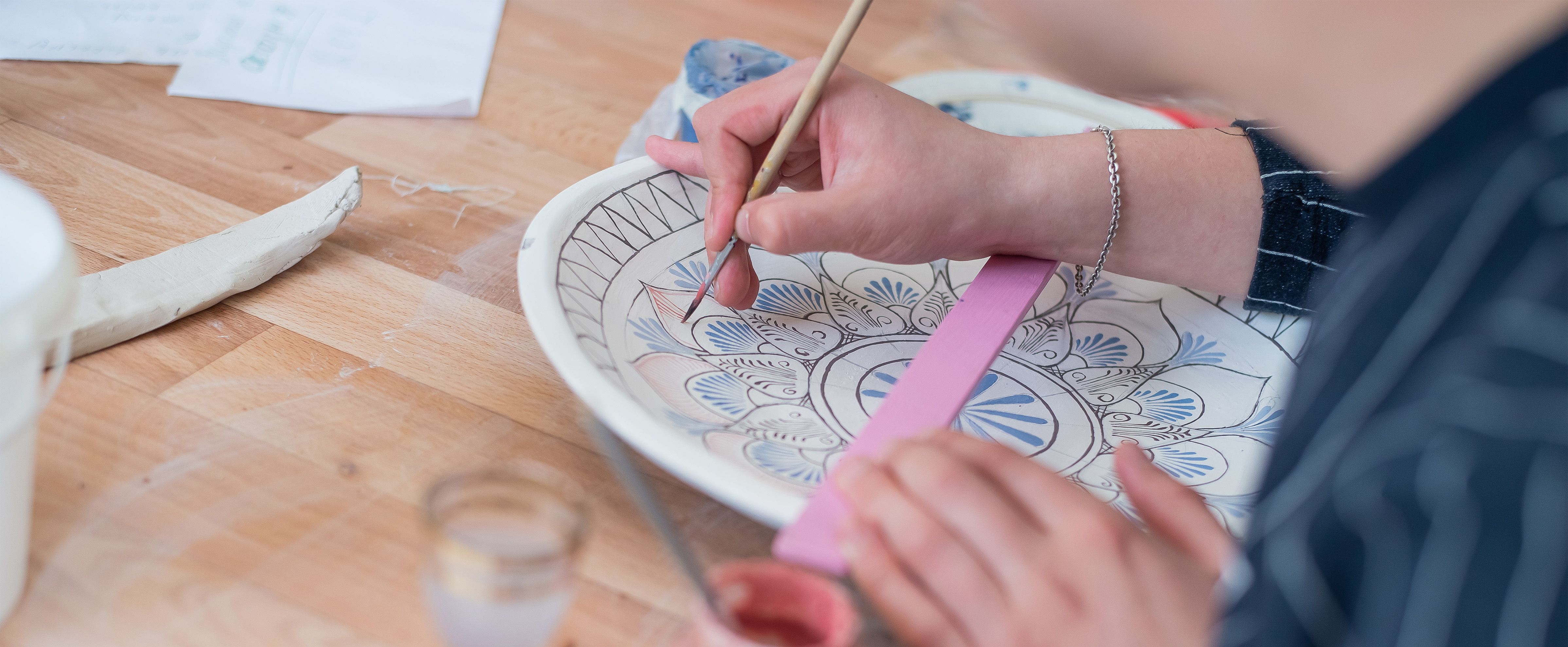 Ciotola in ceramica dipinta a mano con dettagli blu e rosa, progetto decorativo mixed media per adulti.