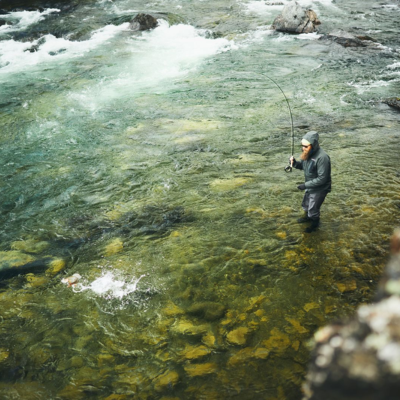 Ein Mann beim Fliegenfischen mitten in einem klaren Fluss mit der neuen Guideline Ausrüstung 2026.png