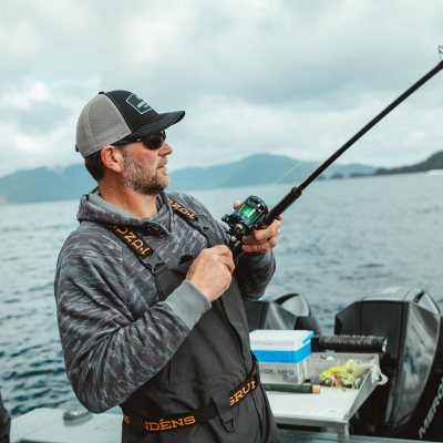 Angler in robuster Grundéns Angelbekleidung steht an einem nebligen See und fischt bei schlechtem Wetter.png