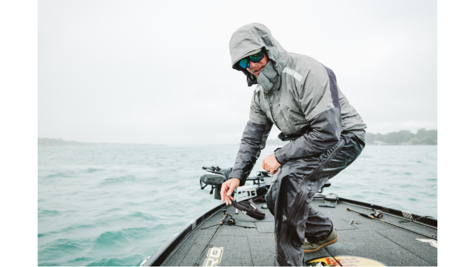 Nahaufnahme eines Fischers in wetterfester Grundéns Regenjacke auf einem Boot bei starkem Wellengang.png