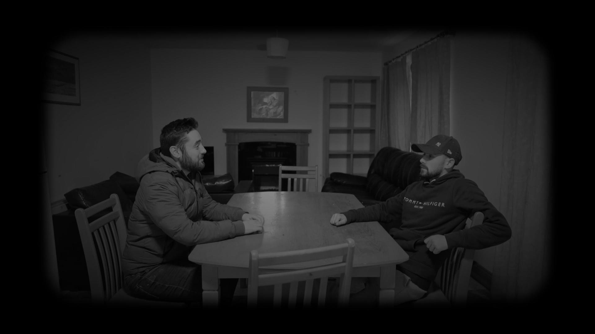Two men sitting at a kitchen table having a conversation