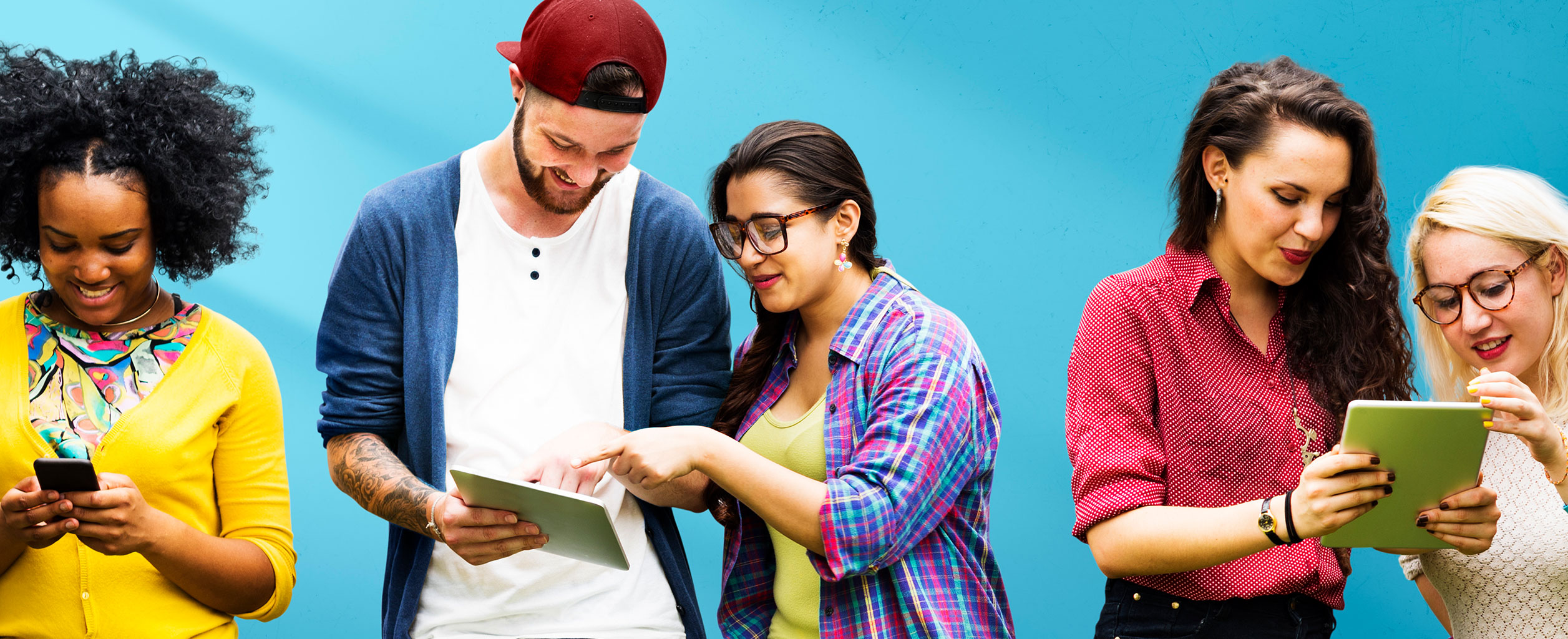 Vier Personen, die vor einem blauen Hintergrund stehen und digitale Geräte wie Tablets und Smartphones benutzen.