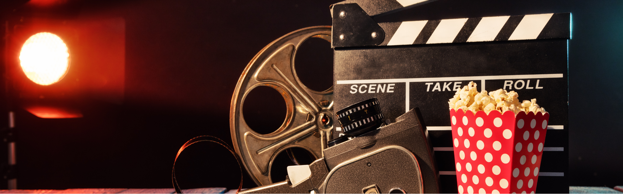 Ein Blogbeitrag zum aktuellen Buchverfilmungen. Auf dem Bild sind eine Kino-Filmrolle, eine Szeneklappe und ein Popcorn zu sehen.