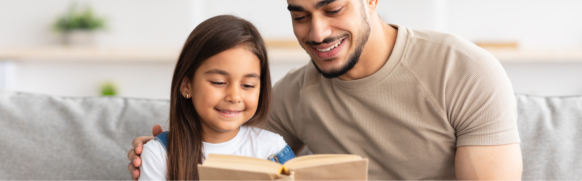 Vater liest Tochter im Grundschulalter vor.png