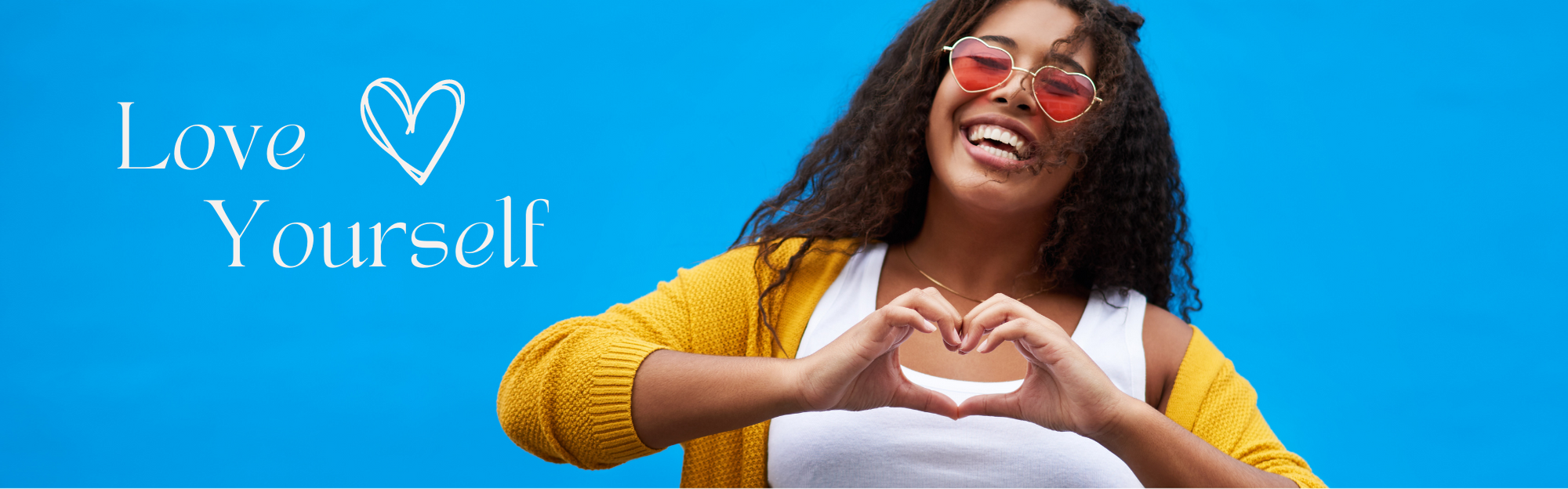 Lächelnde Frau in einer gelben Strickjacke macht mit ihren Händen eine Herzform, neben dem Text Love Yourself auf blauem Hintergrund.