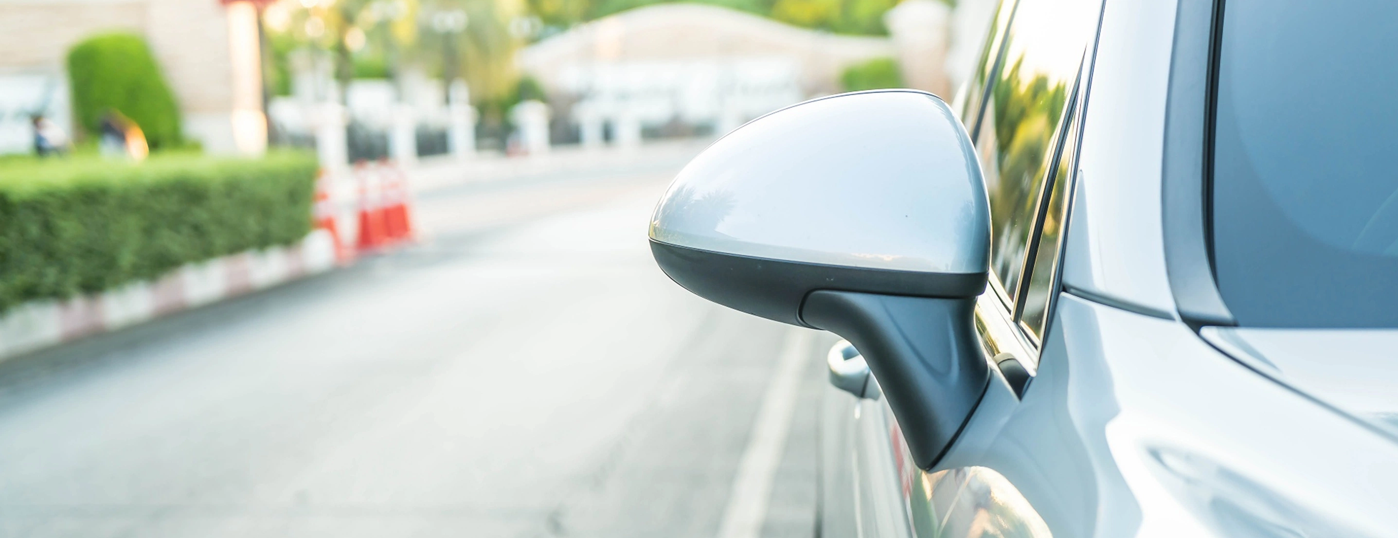Von Vorne aufgenommene Nahaufnahme der linken Seite eines Autos, im Hintergrund eine leere Straße.