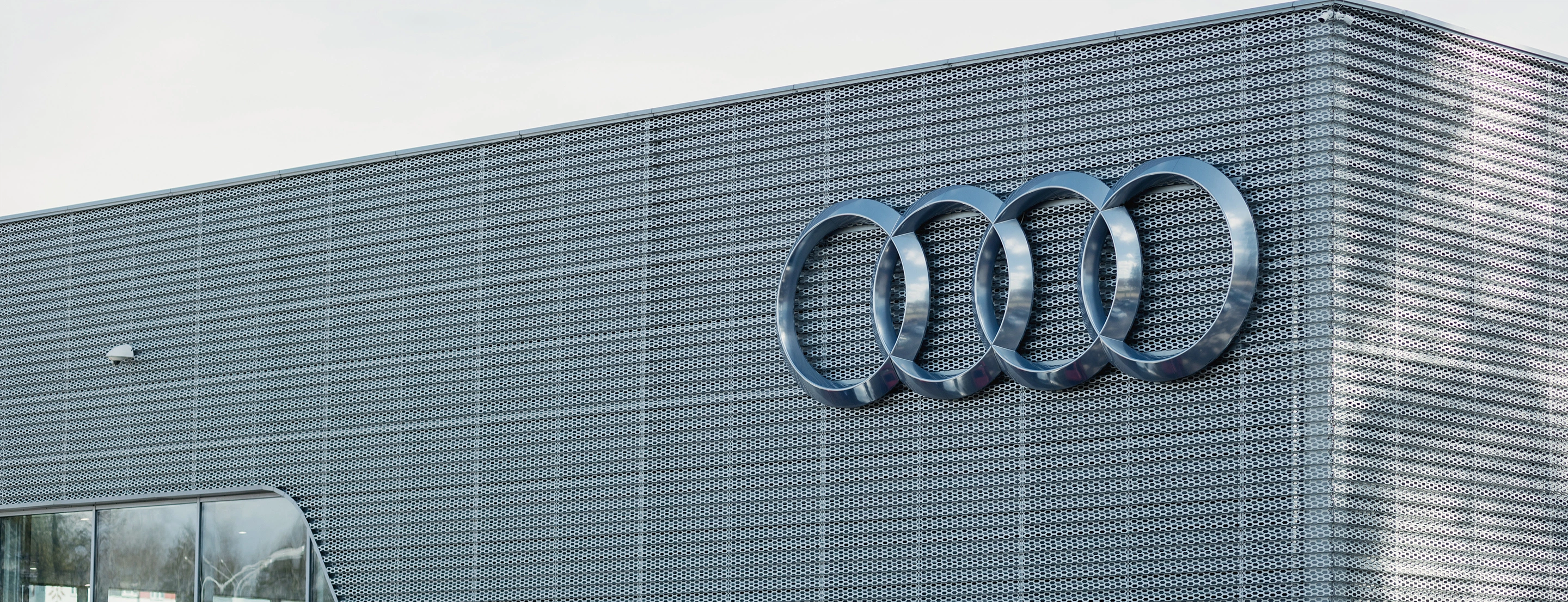 An exterior view of an Audi factory with a large Audi logo.