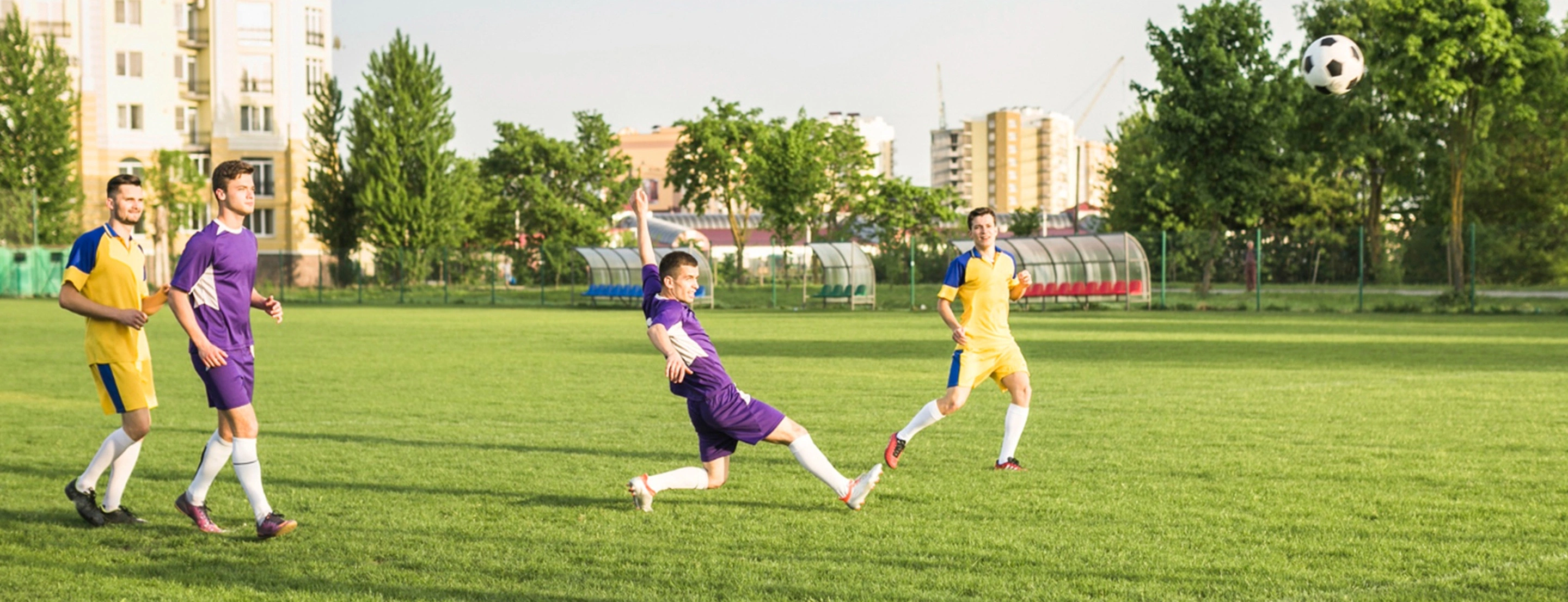4 Personen die in 2 Teams Fußball spielen 