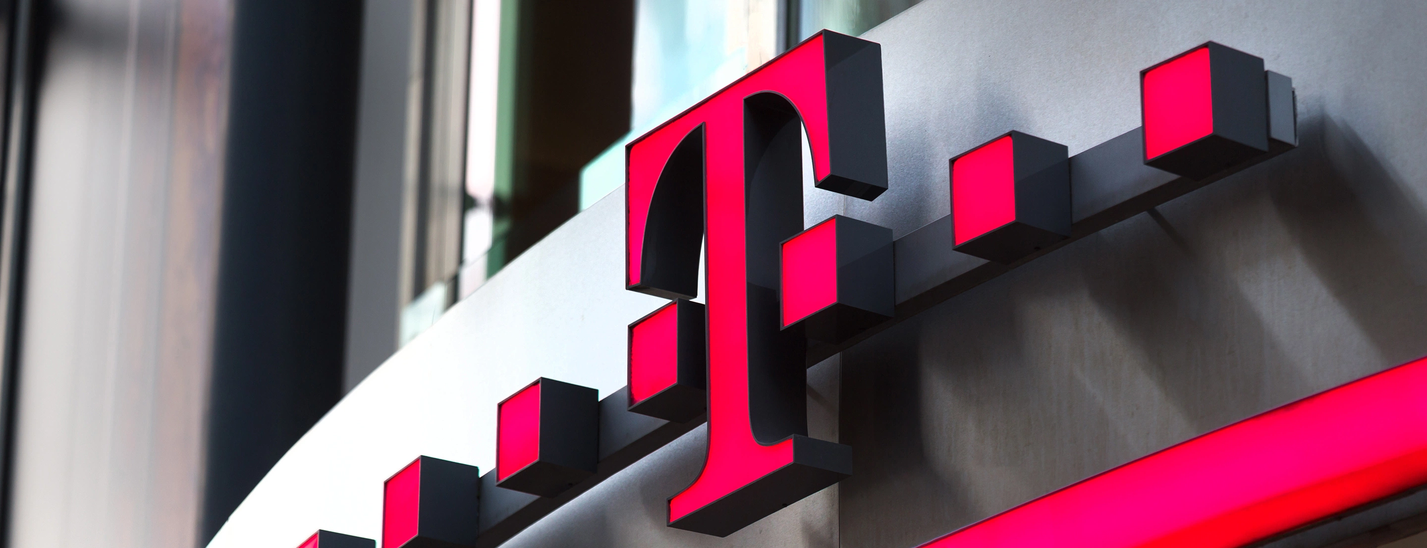 Nahaufnahme eines Telekom Logos einer Filiale.