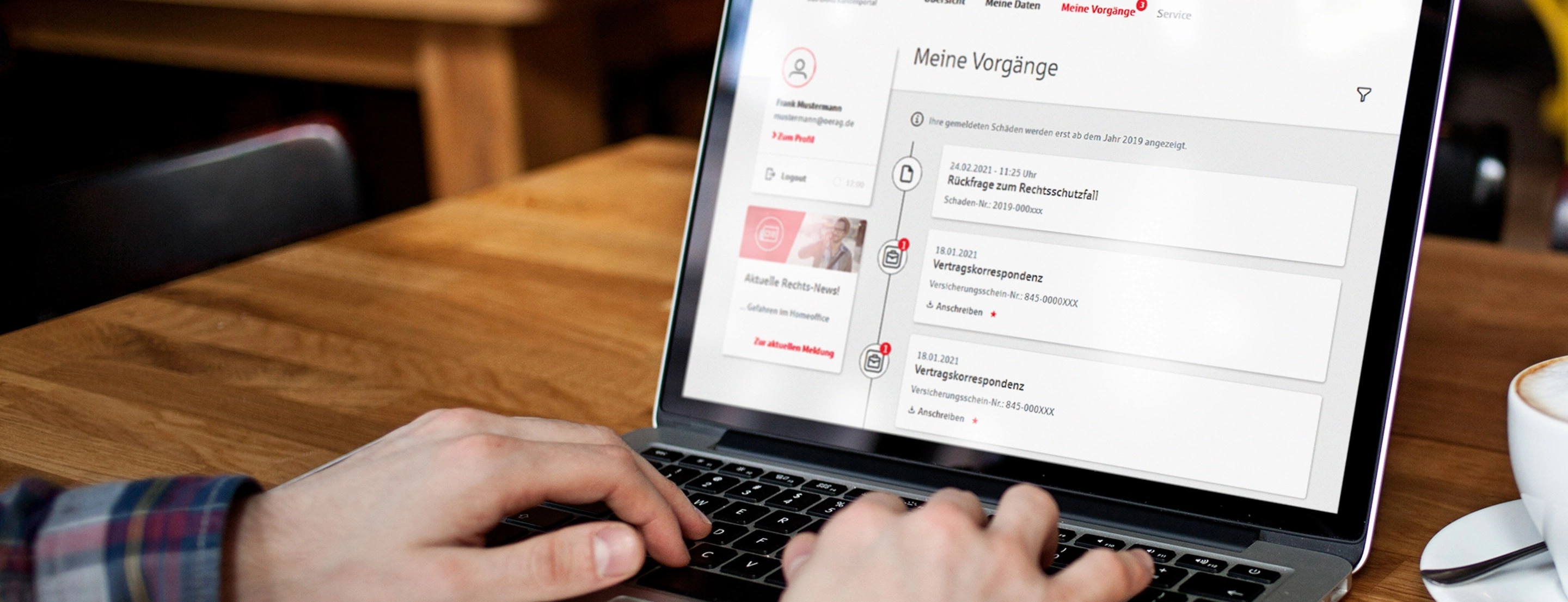 Eine Person an einem Tisch, die an einem Laptop etwas bearbeitet.