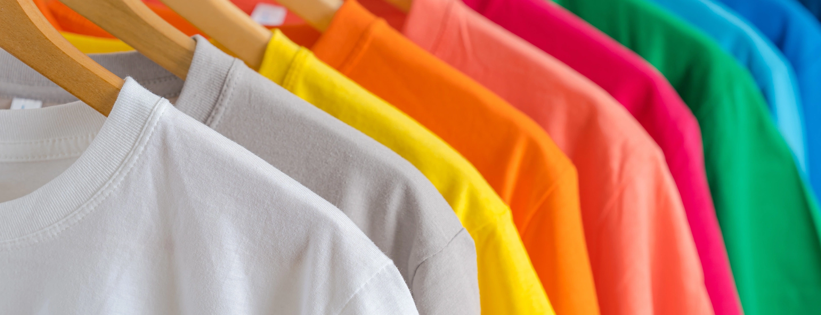 Auf Kleiderbügel aufgehängte Pullover in verschiedenen Farben.