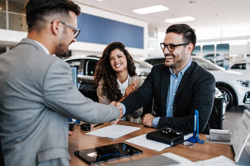 Couple buying car in showroom