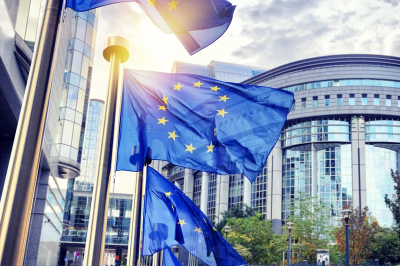 EU flags waving in front of European Parliament building in Brussels