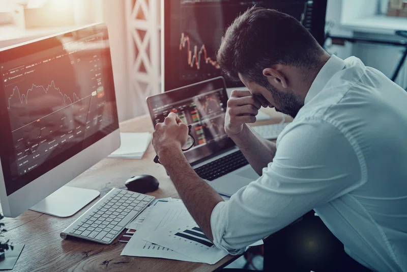 Investor with head in hands