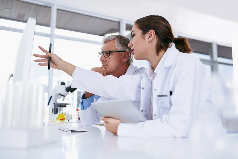 Laboratory technicians looking at computer screen