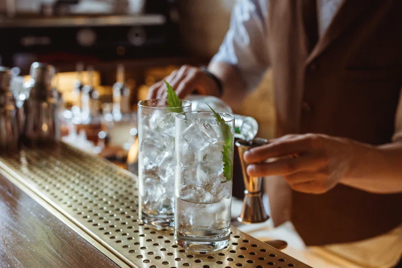 Bar tender pouring gin and tonics