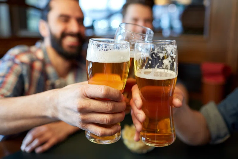 People raising a pint to say cheers