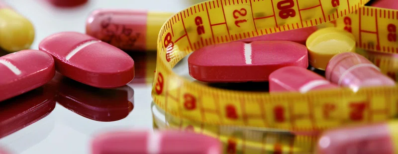 A selection of pills and a tape measure