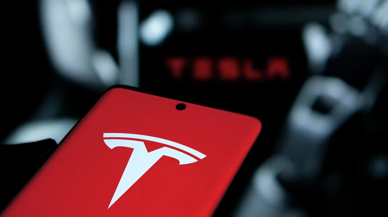Tesla logo against market data background
