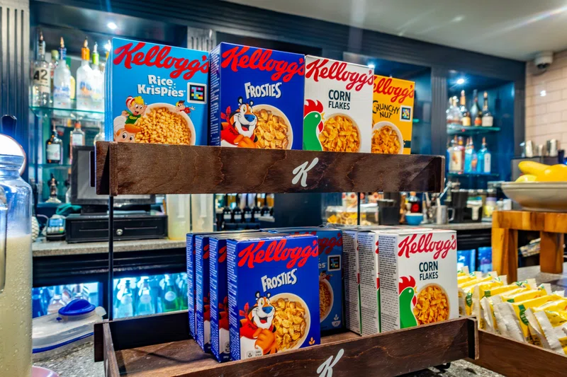 Shopper picking up Kellogg cereals from supermarket shelf