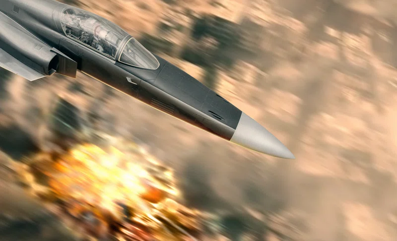 Jet bomber flying over explosion