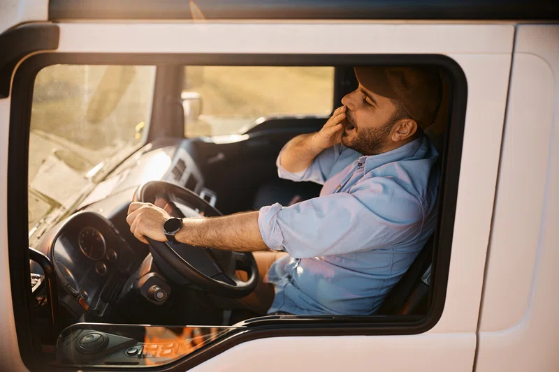 Truck driver yawning at the wheel