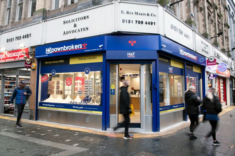 People walking past H&T store