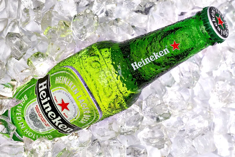 Picture of a Heineken beer bottle sitting on a tray of ice