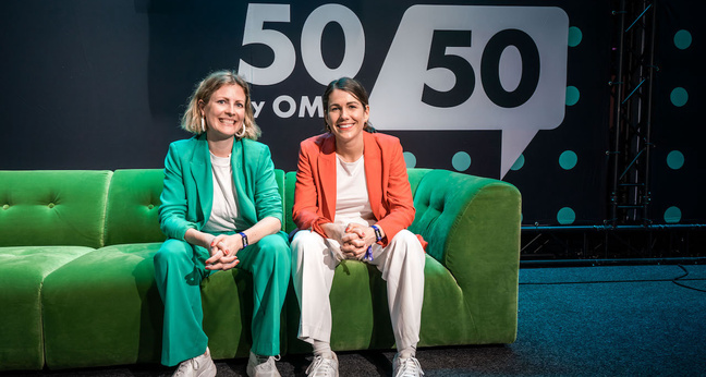 Zwei Frauen sitzen auf einer grünen Couch vor dem 5050-OMR-Logo – Bühnensetting eines Events für Gleichstellung und Gründerinnen.